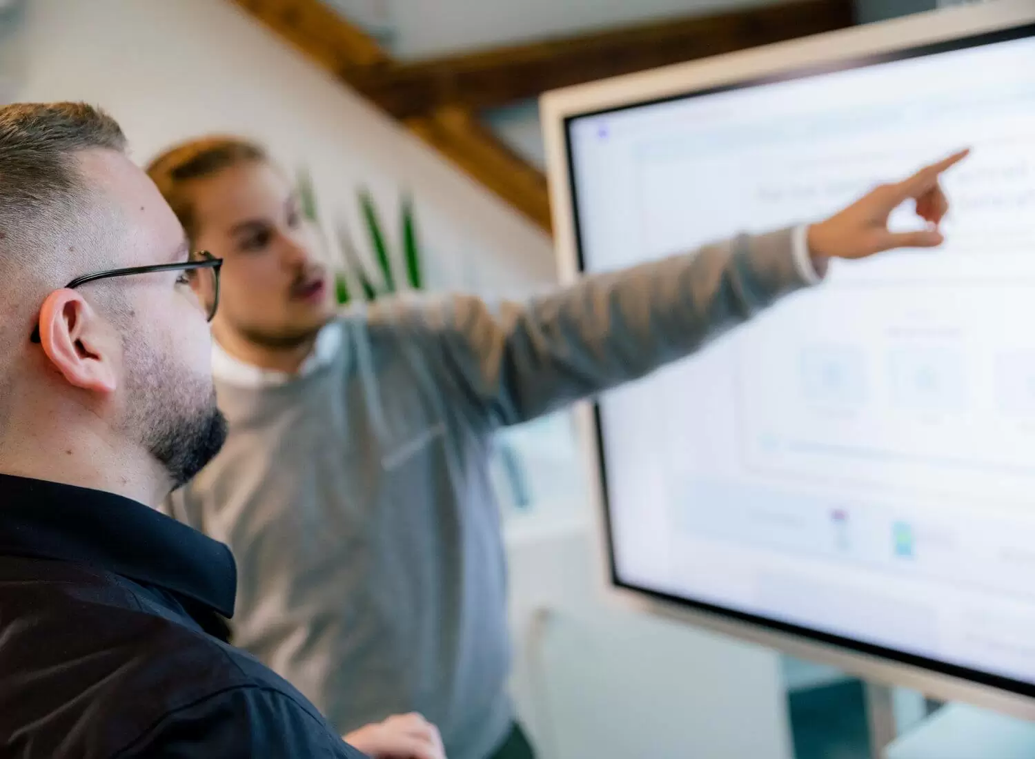 Zwei Männer stehen vor einem Smartboard